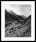 Black and white photograph of a wide alpine valley with a road leading through the High Tauern mountains, from the series High Tauern. The Zone Studies II by Ziggy Kanczukowski